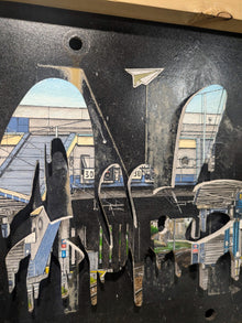 Gros plan sur le graffiti découpé, la gare de Calais et la patine du panneau SNCF